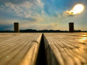 Surface level of wood against sky during sunset