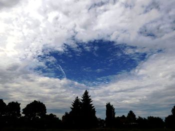 Low angle view of silhouette trees against sky