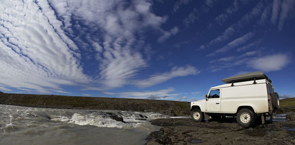 White suv standing at the edge of a waterfall