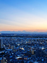 Aerial view of townscape against clear sky at sunset
