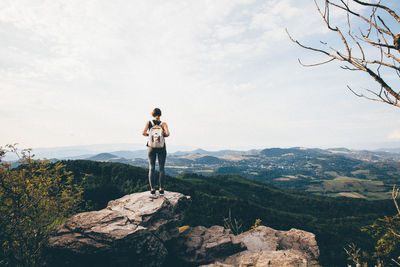 Rear view of woman standing on cliff