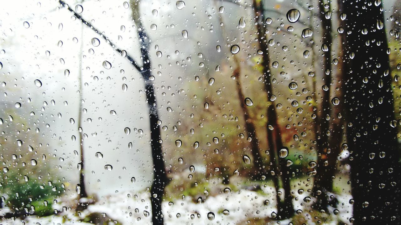 FULL FRAME SHOT OF WET GLASS WINDOW IN RAINY SEASON