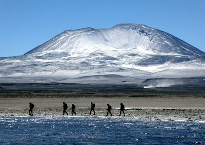 Tourists passing through snow covered mountain