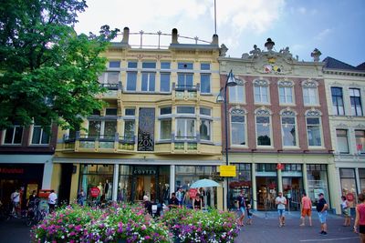 People on street against buildings in city