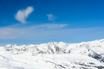 Scenic view of snowcapped mountains against blue sky