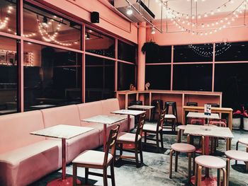 Empty chairs and tables in illuminated restaurant