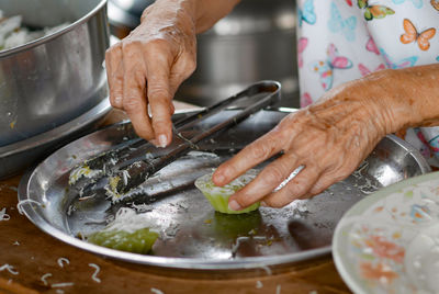 Midsection of person preparing food in kitchen