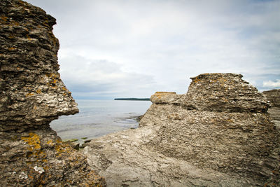Rock formation on beach against sky