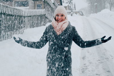 Portrait of smiling woman standing on snow