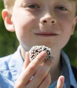 Close-up portrait of boy holding a cake