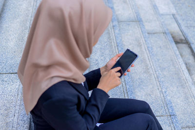 Midsection of man using mobile phone