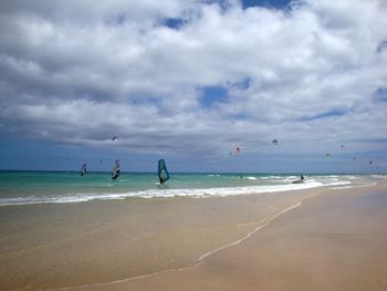 Scenic view of beach against cloudy sky