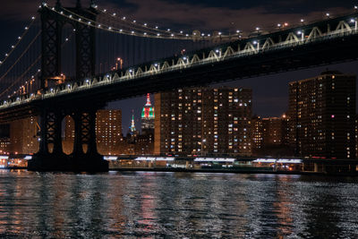 Illuminated brooklyn bridge over river