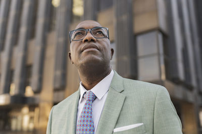 Mature businessman standing in front of building