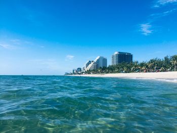 Scenic view of sea against buildings in city