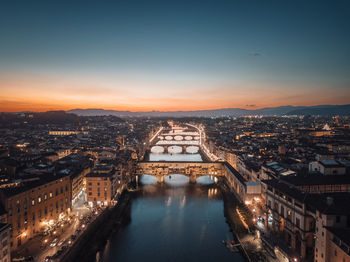 Aerial view of the illuminated city of florence at dusk with the arno river and the ponte vecchio