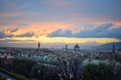 High angle view of trees and buildings against sky during sunset