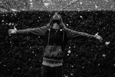 Man with arms outstretched enjoying snow at yard