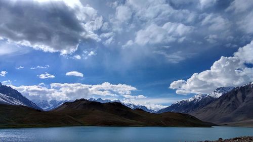 Scenic view of mountains and lake against cloudy sky