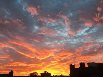 Low angle view of silhouette buildings against dramatic sky