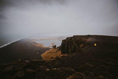 Man on cliff against sky