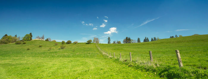 Scenic view of grassy field against cloudy sky