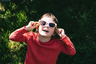 Happy child looking up at the sun in sunglasses. summer is a time of pleasure and fun. 