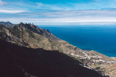 Scenic view of sea and mountains against sky