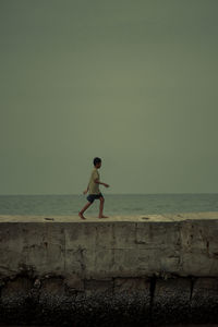 Full length of man standing by sea against sky