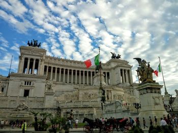 Low angle view of statues against cloudy sky