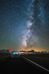 Car on road against sky at night