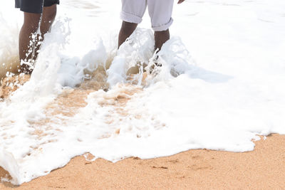 Midsection of men at beach