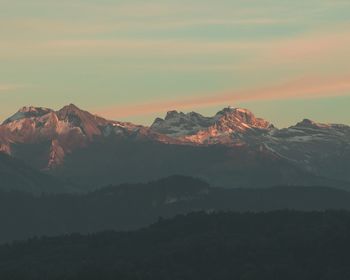 Scenic view of snowcapped mountains against sky during sunset