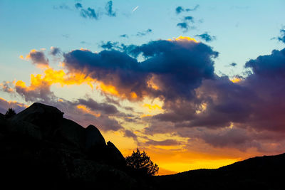 Low angle view of silhouette mountains against dramatic sky