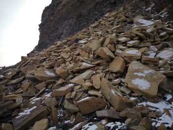 Low angle view of rocks on mountain against sky