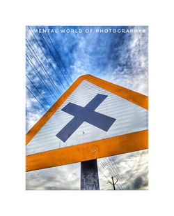 Digital composite image of road sign against blue sky