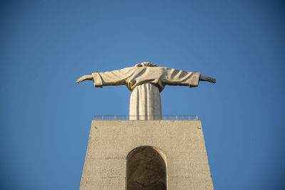 Low angle view of statue against clear blue sky