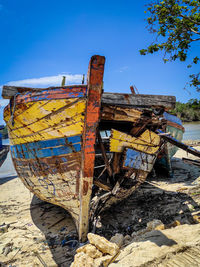 Old rusty ship on beach against sky