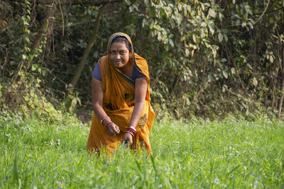 Portrait of smiling woman wearing sari working at agricultural field india