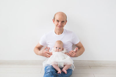 Portrait of a smiling girl holding baby