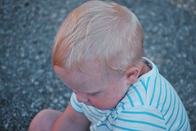 Side view of cute boy sitting outdoors