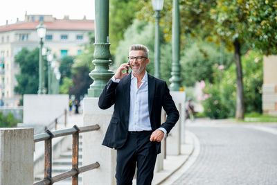 Man holding umbrella standing in city