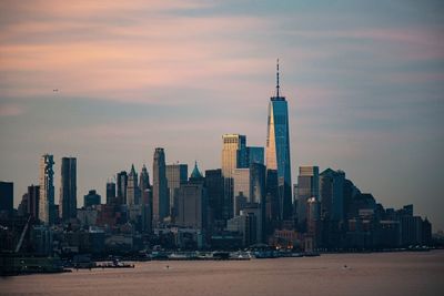 View of buildings in lower manhattan against cloudy sky during sunset