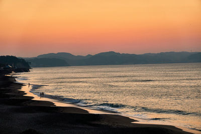 Scenic view of sea against orange sky during sunrise