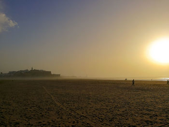 Scenic view of beach against sky during sunset