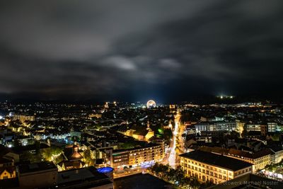 Illuminated cityscape against sky at night