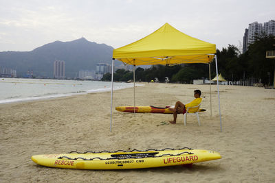 Man on yellow beach against sky