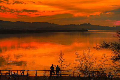 Silhouette of a couple at a scenic view at lake mutanda at sunset in kisoro town, uganda