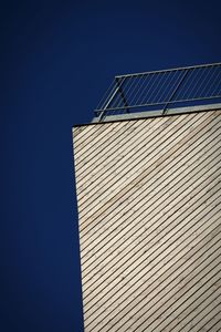 Low angle view of tall building against blue sky