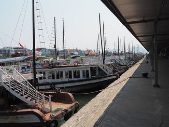 Sailboats moored at harbor against sky